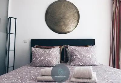 a bedroom with a bed with pillows and a clock on the wall at Apartment Sant'Ana Old Town Albufeira - Bay View in Albufeira