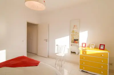 a bedroom with a bed and a dresser and a desk at Modern Apartment by the Sea in Quarteira