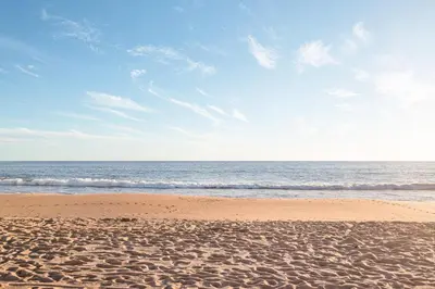 a sandy beach with the ocean in the background at Modern Apartment by the Sea in Quarteira