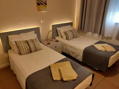 two beds in a hotel room with towels on them at Varandas Golden Beach in Quarteira
