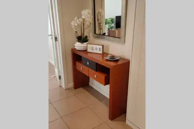 a hallway with a wooden dresser and a mirror at Varandas Golden Beach in Quarteira