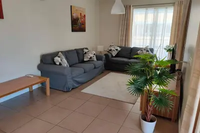 a living room with two couches and a plant at Varandas Golden Beach in Quarteira