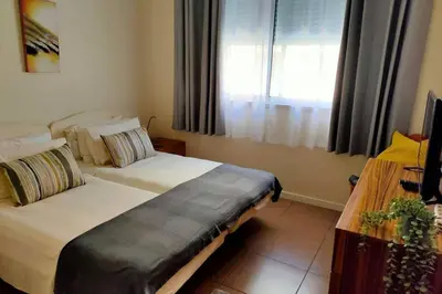 a bedroom with two beds and a window at Varandas Golden Beach in Quarteira