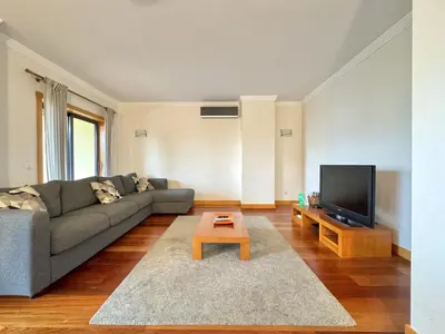 a living room with a couch and a tv at Albufeira Modern 1 with pool by Homing in Albufeira
