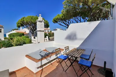 a patio with chairs and a bench and a table at Casa Vale Do Lobo 32 Charming 2 Bedroom Townhouse Close To Beach in Vale do Lobo