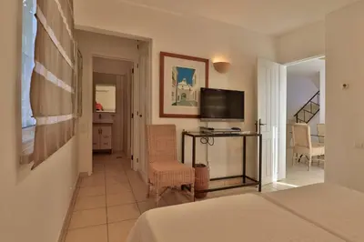 a hotel room with a bed and a television at Casa Vale Do Lobo 32 Charming 2 Bedroom Townhouse Close To Beach in Vale do Lobo