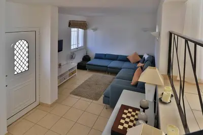 a living room with a blue couch in a room at Casa Vale Do Lobo 32 Charming 2 Bedroom Townhouse Close To Beach in Vale do Lobo
