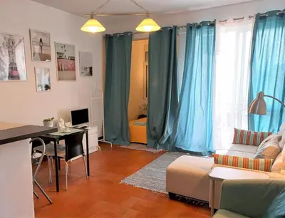 a living room with blue curtains and a table and a couch at Apartament near the ocean in Albufeira