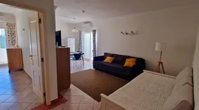 a living room with a couch and a table at Praia Oura Sunset in Albufeira