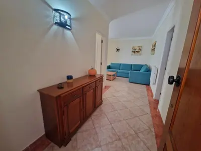 a living room with a blue couch and a table at Praia Oura Sunset in Albufeira