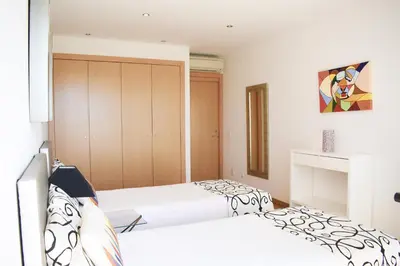 two beds in a bedroom with white walls at Villas Rocha in Albufeira