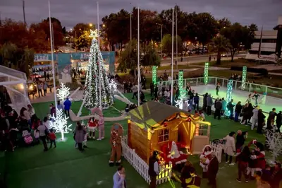 a group of people standing around a christmas tree at 