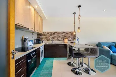 a kitchen with a table and a blue couch at Medronheira B2 - Dream Lodging in Albufeira