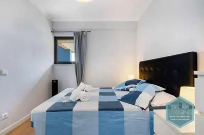 a bedroom with a blue and white bed with towels at Forte 303 - Dream Lodging in Albufeira