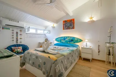 a bedroom with a bed with a blue bedspread at Casinha da Ti Babel in Faro
