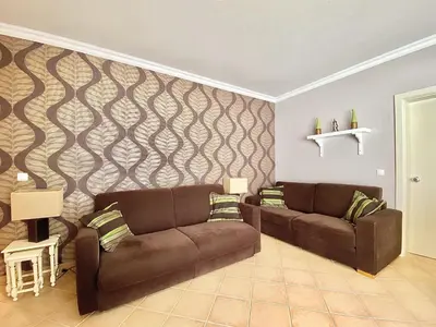 a living room with two brown couches and a wall at Tália X - Near the beach - Vilamoura in Vilamoura