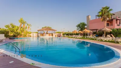 a pool at a resort with chairs and a gazebo at Greice Homes-Luxury 2 bed en-suite south facing & Golf view in Quarteira