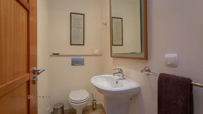 a bathroom with a sink and a toilet and a mirror at Greice Homes-Luxury 2 bed en-suite south facing & Golf view in Quarteira