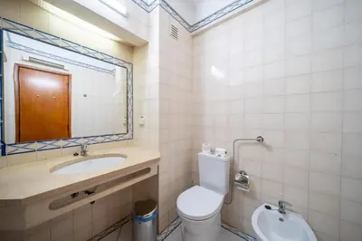 two beds in a room with a desk and a window at Bellavista Avenida By BeGuest in Albufeira