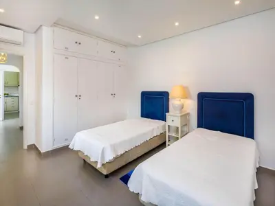 two beds in a room with white walls and blue headboards at Villa Oceano Golf 482 2 Bedrooms Sea Views A Stone's Throw To The Beach in Vale do Lobo