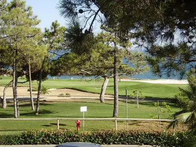 a golf course with a red fire hydrant and trees at Villa Oceano Golf 482 2 Bedrooms Sea Views A Stone's Throw To The Beach in Vale do Lobo