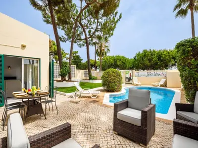 a patio with a table and chairs and a pool at Villa Oceano Golf 482 2 Bedrooms Sea Views A Stone's Throw To The Beach in Vale do Lobo
