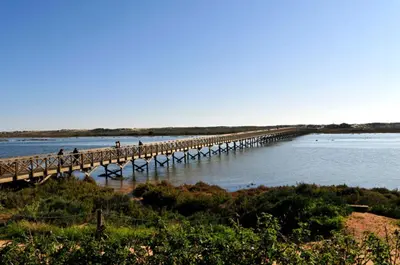 a bridge over a body of water with people on it at Charming Vale Do Lobo Villa Casa Vale Do Lobo 832A 3 Bedrooms in Vale do Lobo