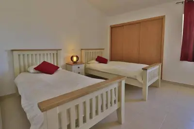 a bedroom with two beds with red pillows on them at Charming Vale Do Lobo Villa Casa Vale Do Lobo 832A 3 Bedrooms in Vale do Lobo