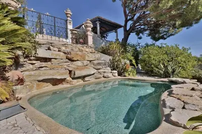 a swimming pool with a stone wall and a house at Villa Vale Do Lobo 409 Beautiful 5 Bedrooms Heated Pool Short Walk in Vale do Lobo