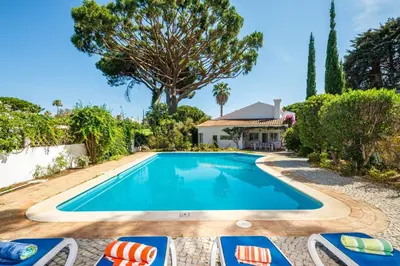 a swimming pool with lounge chairs and a house at Villa Quadradinhos 38Q 4 Bedrooms Private Pool Short Walk To The Beach in Vale do Lobo