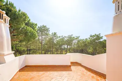 a balcony of a building with trees in the background at Charming Vale Do Lobo Villa Private Pool Villa Vale Do Garro 51 in Vale do Lobo