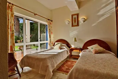 a bedroom with two beds and a large window at Villa Quadradinhos 3Q 4 Bedrooms Private Pool Short Walk To The Praca in Vale do Lobo