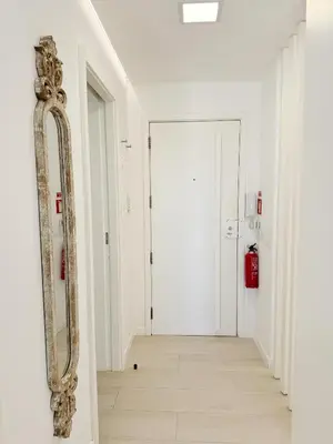 a mirror on a wall in a hallway at Seafront Apartment in Quarteira in Quarteira