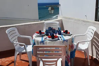 a table with white chairs and a table with food on it at Casa do Avô in Albufeira