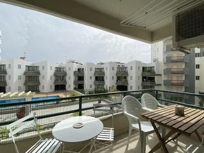 a balcony with tables and chairs and a view of buildings at Tália XI - Near the beach - Vilamoura in Vilamoura