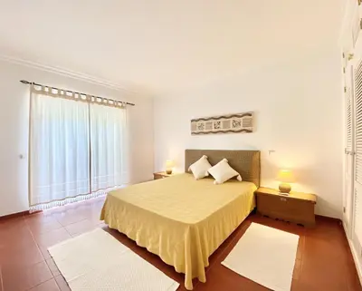 a bedroom with a bed and a large window at Vila Pereira - Private Pool - Vilamoura in Vilamoura