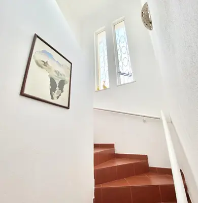 a staircase with two windows and a picture on the wall at Vila Pereira - Private Pool - Vilamoura in Vilamoura