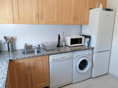 a kitchen with a sink and a washing machine at Bel Appartement 2 chambres au cœur d’Albufeira, proche de la magnifique plage de Oura et des loisirs in Albufeira
