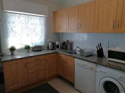 a kitchen with a sink and a washing machine at Bel Appartement 2 chambres au cœur d’Albufeira, proche de la magnifique plage de Oura et des loisirs in Albufeira