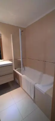 a bathroom with a bath tub with a towel on it at Bel Appartement 2 chambres au cœur d’Albufeira, proche de la magnifique plage de Oura et des loisirs in Albufeira