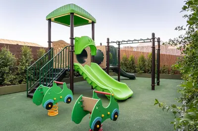 a playground with a green slide in a yard at 3HB Faro in Faro