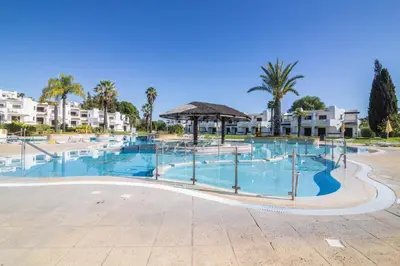 a large swimming pool at a resort with palm trees at Albufeira Apartment in Albufeira