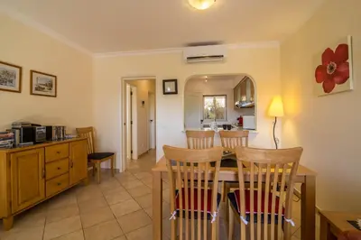 a kitchen with wooden cabinets and a sink and a window at Albufeira Apartment in Albufeira