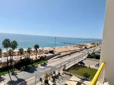 a view of a beach and the ocean from a building at Apartamento Frente praia in Quarteira