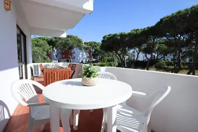 a white table and chairs on a balcony at Sea Gardens - Alvaflor - Vilamoura in Vilamoura