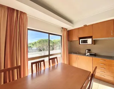 a kitchen with a table and a large window at Sea Gardens - Alvaflor - Vilamoura in Vilamoura
