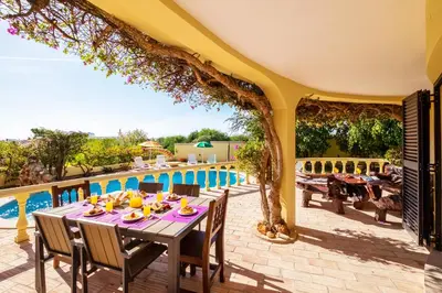 a patio with a table and chairs next to a pool at Villa Bantayan by Algarve Vacation in Albufeira