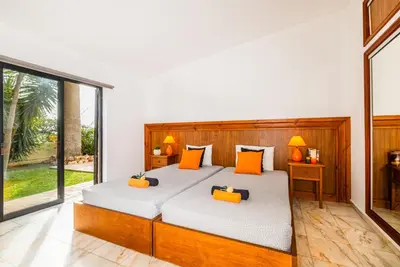 a bedroom with a large bed with orange pillows at Villa Bantayan by Algarve Vacation in Albufeira