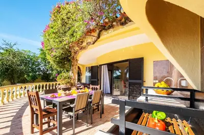 an outdoor dining area with a table and chairs on a deck at Villa Bantayan by Algarve Vacation in Albufeira