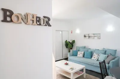 a living room with a blue couch and a table at Serenity by Intiholidays in Quarteira